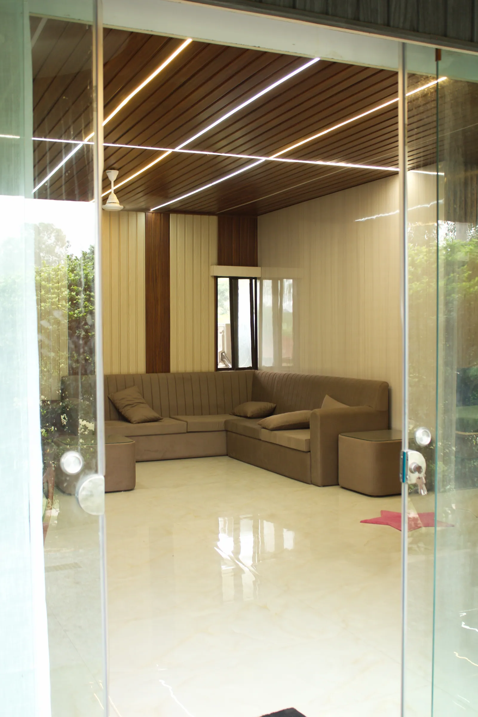A corner sofa in the farmhouse lounge seen through the glass doors at Raj Organic Farm